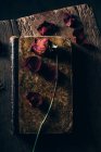 Вид сверху на высохшую розу на старой книге за сельским деревянным столом — стоковое фото