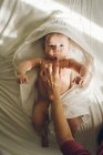 Crop mano toccando mento del neonato sdraiato su asciugamani e guardando la fotocamera . — Foto stock