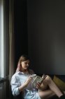 Seitenansicht einer Frau, die zu Hause im Bus Buch liest — Stockfoto