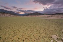 Paisagem de leito de rio seco devido à seca sob paisagem nebulosa cênica — Fotografia de Stock