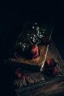 Natura morta di rosa secca e piccoli fiori bianchi su vecchio libro a tavolo di legno rurale — Foto stock