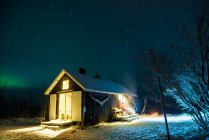 Blick auf beleuchtetes Holzchalet im Winter — Stockfoto