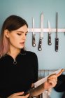 Portrait of young sensual woman posing with knife at kitchen. — Stock Photo