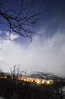 Petit village éclairé dans le paysage de nuit d'hiver — Photo de stock