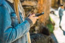 Mädchen benutzt Smartphone im Park — Stockfoto