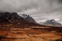Панорамний вид на туманні гори і сухі трав'яні поля — стокове фото