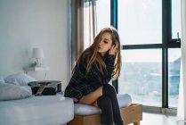 Ritratto di giovane ragazza elegante seduta sul letto con chitarra — Foto stock