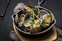Натюрморт из моллюсков с соусом белого вина подается в сельской кастрюле — стоковое фото