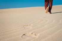 Baixa seção de caminhada masculina na areia ondulada — Fotografia de Stock