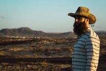Vue latérale de l'homme barbu en chapeau à la vallée sèche — Photo de stock