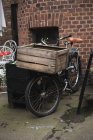 Bicicleta estacionada con caja de madera como maletero delantero en calle . - foto de stock