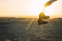 Erntehand zeigt Trekkingstiefel im Sonnenlicht — Stockfoto