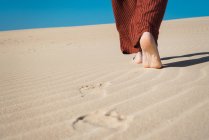 Мужские ступни, ходящие по волнообразному песку — стоковое фото