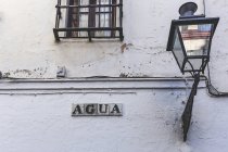 Деревянная стена с фонариком и надписью агуа — стоковое фото