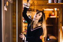 Молодая женщина заманчиво позирует в черном свитере на фоне интерьера дома . — стоковое фото
