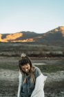 Portrait de jeune femme enlevant son manteau à la prairie — Photo de stock