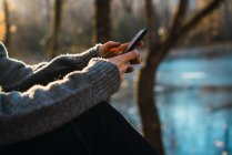 Cortar smartphone de navegação feminina no parque de outono — Fotografia de Stock