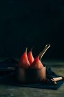 Poached pears in red wine with cinnamon and spices in saucepot on table — Stock Photo