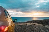 Автомобиль на скалистом берегу океана — стоковое фото
