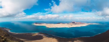Panoramic distant view of small island in blue sea — Stock Photo