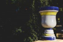 Verzierte Keramikvase am Geländer bei grünen Bäumen — Stockfoto