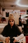 Портрет молодої жінки, що сидить за столом у кафе та п'є каву . — стокове фото