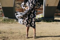 Crop woman in beautiful dress posing under bridge — Stock Photo