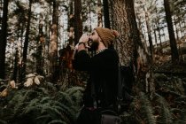 Seitenansicht eines verlorenen Touristen, der im sonnigen Wald steht und schreit. — Stockfoto