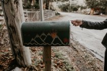 Crop person opening mailbox on roadside — Stock Photo