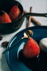 Close up view of served in ceramic plate poached pears on table — Stock Photo