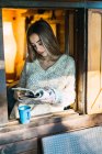 Porträt eines Mädchens mit Buch und Kaffee im Fenster — Stockfoto