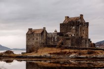 Внешний вид замка на берегу озера в туманный день — стоковое фото