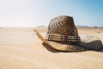 Vista de cerca del sombrero de paja vaquero en la arena - foto de stock