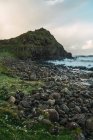 Paesaggio vista verde collina e pietre al mare — Foto stock