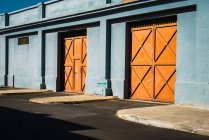 Vue extérieure des portes orange en mur bleu — Photo de stock