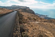 Camino de asfalto en roca costera a orillas del mar - foto de stock