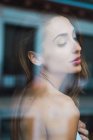 View through window of sensual woman with eyes closed — Stock Photo