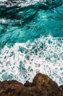 From above view of coastal rocks and turquoise wavy ocean — Stock Photo