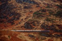 Aerial view of train riding in mountains — Stock Photo