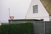 Buisson vert et panneau de signalisation à la maison blanche dans la campagne . — Photo de stock