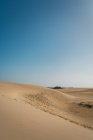 Пейзаж бесконечного песчаного берега под кипящим солнцем — стоковое фото