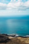 Vue lointaine du petit bateau naviguant en mer bleue — Photo de stock