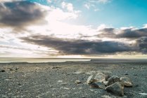 Paisagem de beira-mar com pedras e rochas na praia cinza . — Fotografia de Stock