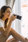Side view of woman taking shot with camera — Stock Photo