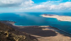 Panoramic view to coast and small island in blue ocean — Stock Photo