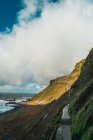 Vista panorâmica para estrada de asfalto na colina verde à beira-mar — Fotografia de Stock
