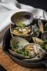 Crop Spanish clam stew in white wine sauce on pan at board — Stock Photo