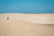 Visão traseira do viajante com mochila andando em dunas de areia — Fotografia de Stock