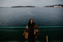 Женщина позирует на пароме на фоне моря — стоковое фото