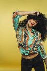 Donna ridente con i capelli ricci in posa in studio — Foto stock